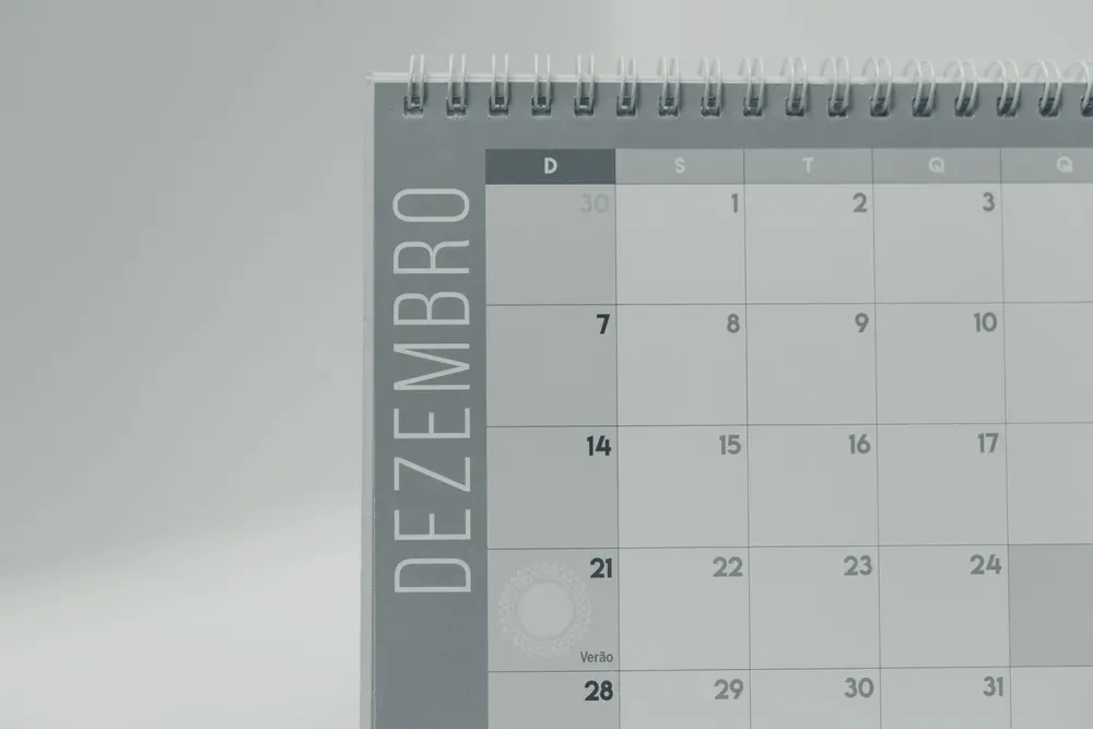 Calendário de mesa espiral aberto no mês de dezembro, com os dias organizados em grade.