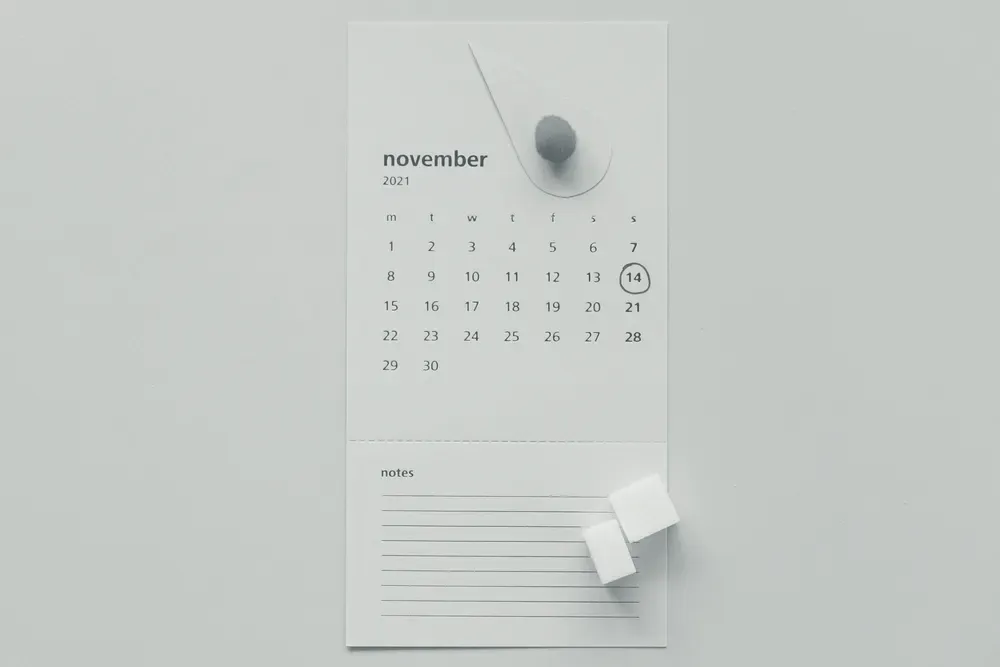 Calendário de parede com um dia circulado e um recorte decorativo em formato de gota sobre a folha